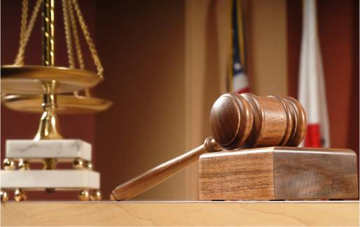 Judge's desk with gavel, balance scale, and American flag, representing legal news and insights